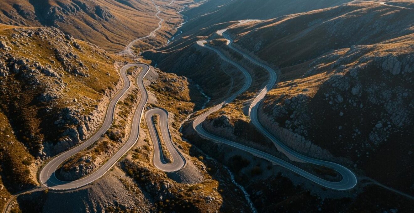 Paysage routier vu du dessus mettant en évidence les virages serrés et le relief montagneux sur une portion de route.